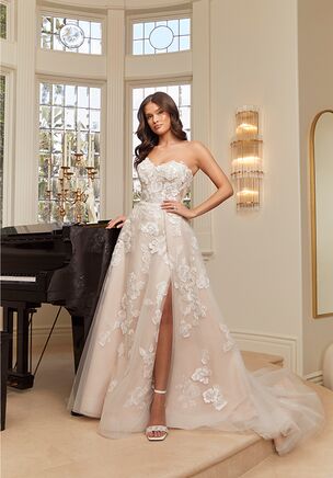 Get swept away in the fairytale romance of style 2559 Maude, a charming A-line wedding gown of elegant floral lace appliqués and tulle. Her embellished sweetheart neckline and detachable, sheer off-shoulder sleeves highlight her bodice with built in 15-point boning. This supportive structure creates a flawless fit for all shapes and sizes. From the waist, this timeless A-line silhouette softly skims the figure, opening at the thigh for a sultry leg slit. Delicate floral lace appliqués with sequins scatter across flowy layers of tulle culminating in a stunning 70-inch train in the back. Maude is also available with the option to line the bodice for a more modest look. Maude's matching accessories include detachable, fitted tulle illusion sleeves (SL045) and a matching fingertip veil, 2559V, offered separately. 