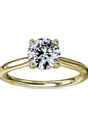 Classic from a bird's-eye view, this 14k yellow gold solitaire has a delicate diamond profile and slight cathedral that put your center stone on display.
