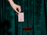 Woman's hand holding pink credit card over wien glass, best credit cards for wedding