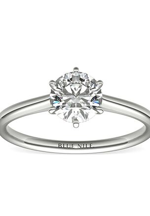 Elegant in simplicity, this petite nouveau solitaire engagement ring is crafted in polished 14k white gold to create a classic frame for your center diamond.
